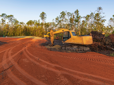 A yellow bulldozer sitting on top of a dirt road