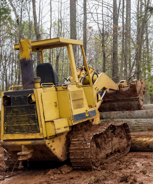 A yellow bulldozer is parked in the mud