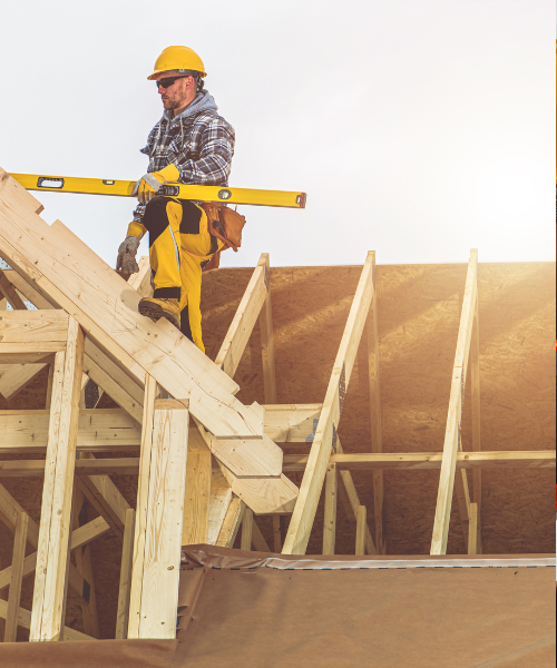 A man in a yellow helmet is on a ladder