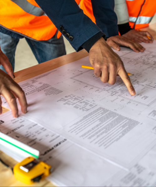 A group of construction workers standing around a blueprint